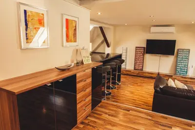 a bar with black bar stools in a room at SKOL apartments in Celje
