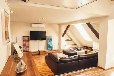 a living room with a couch and a tv at SKOL apartments in Celje