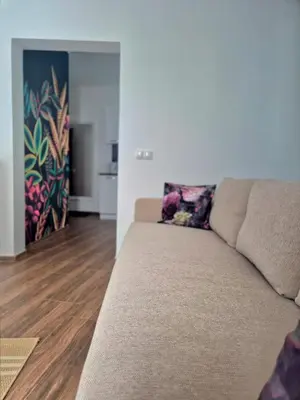 a couch in a living room with a painting on the wall at SKOL apartments in Celje