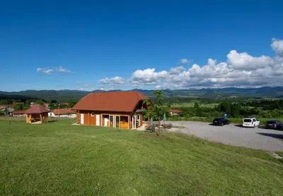 a house on a hill with a parking lot at Camp The sunrise hill in Pivka