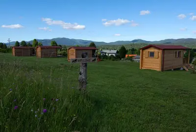 a sign in the middle of a field with houses at Camp The sunrise hill in Pivka