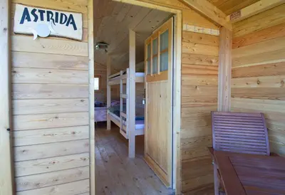 a log cabin with a dining room and bunk beds at Camp The sunrise hill in Pivka