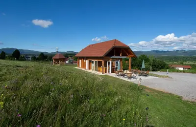 a small building on a hill with a grass field at Camp The sunrise hill in Pivka