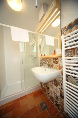 a bathroom with a sink and a shower at Planinski dom Savica in Bohinj