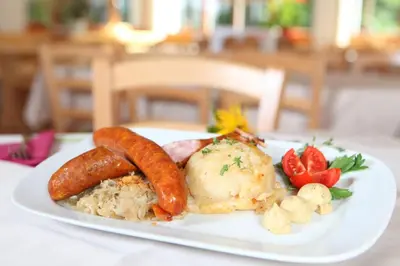 a plate of food with carrots and vegetables on a table at Planinski dom Savica in Bohinj