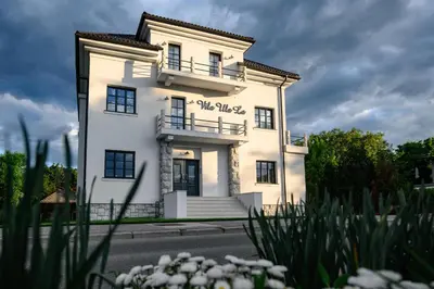 a white building with a balcony on the side of it at Vila Ula La Luxury Apartments in Bled