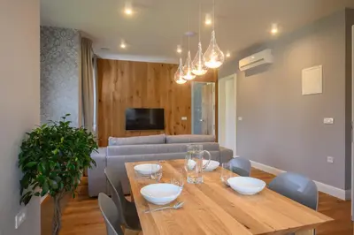 a dining room with a table and a couch at Vila Ula La Luxury Apartments in Bled
