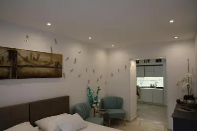 a bedroom with a bed and two chairs and a kitchen at Love Nest apartment in Ljubljana