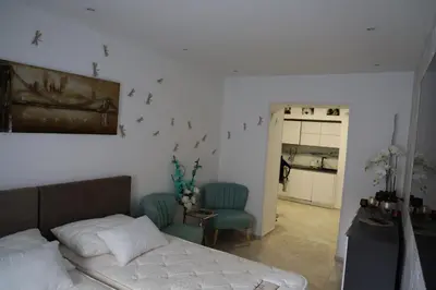 a bedroom with a bed and two blue chairs at Love Nest apartment in Ljubljana