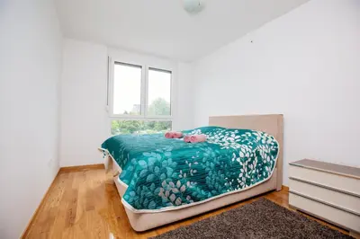 a bedroom with a bed and a window at Bright 2-Bed Apartment Free Parking & WiFi - Walk to Old Town in Ljubljana