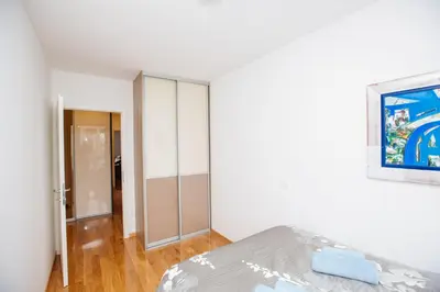 a bedroom with a bed and a painting on the wall at Bright 2-Bed Apartment Free Parking & WiFi - Walk to Old Town in Ljubljana