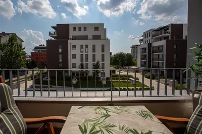 a balcony with a table and a view of buildings at Bright 2-Bed Apartment Free Parking & WiFi - Walk to Old Town in Ljubljana