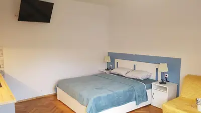a bedroom with a large bed with a blue blanket at Apartma Lahinja in Gradac