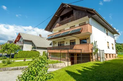 a white house with a gambrel roof at Apartmaji Anja in Bled