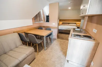 a small kitchen and living room with a couch and a table at Guesthouse Mars in Ig