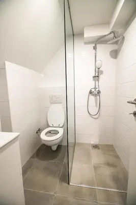 a bathroom with a toilet and a glass shower at Guesthouse Mars in Ig