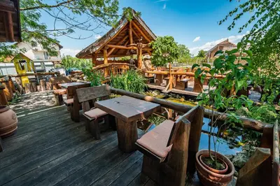a wooden deck with tables and benches and a pavilion at Guesthouse Mars in Ig