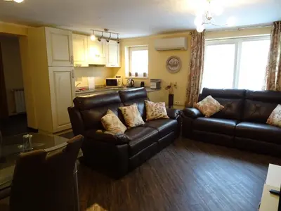 a living room with two leather couches and a kitchen at Kramer Hiša in Kobarid