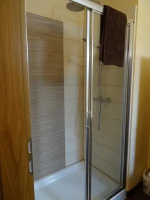 a shower with a glass door in a bathroom at Kramer Hiša in Kobarid