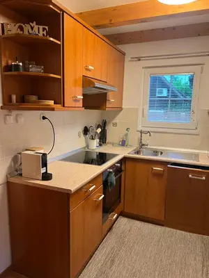 a kitchen with wooden cabinets and a sink at Bella Mura Nature House I26 in Podčetrtek