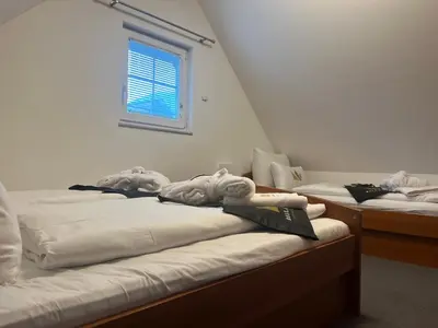 a row of beds in a room with a window at Bella Mura Nature House I26 in Podčetrtek