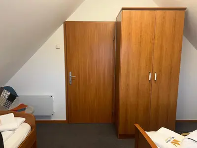 a bedroom with two wooden cabinets and a bed at Bella Mura Nature House I26 in Podčetrtek