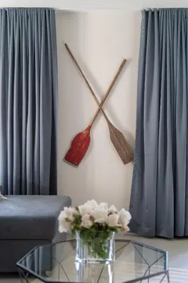 a living room with a couch and a clock on the wall at Pr' Kramarju - House in the heart of Kobarid in Kobarid