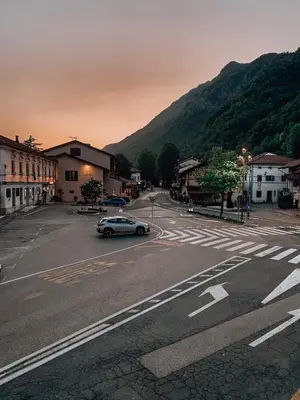 a car driving down a street with a mountain at Pr' Kramarju - House in the heart of Kobarid in Kobarid