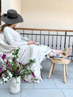 a woman in a hat sitting on a bench at Pr' Kramarju - House in the heart of Kobarid in Kobarid