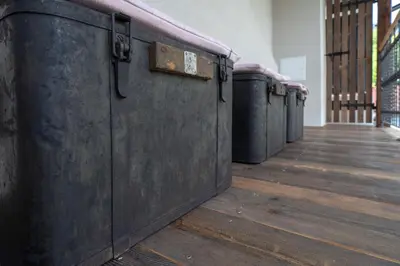 a row of metal bins in a room with wooden floors at Pr' Kramarju - House in the heart of Kobarid in Kobarid