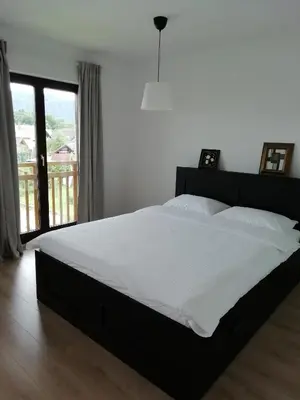 a bedroom with a large bed with white sheets at CARNIOLAN HOUSE - GORENSKA HIŠKA in Radovljica