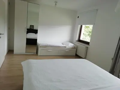 a white bedroom with a bed and a mirror at CARNIOLAN HOUSE - GORENSKA HIŠKA in Radovljica