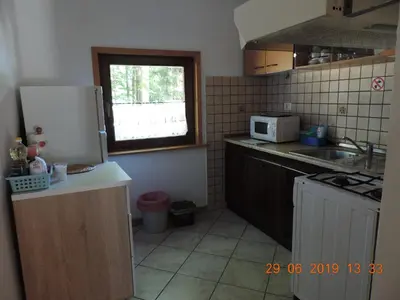 a kitchen with a white refrigerator and a window at Guest House Nanos in Vipava