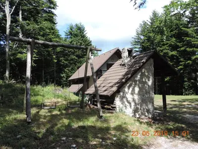 a small building with a roof in the grass at Guest House Nanos in Vipava