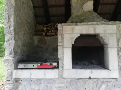 a stone fireplace with a stove in it at Guest House Nanos in Vipava