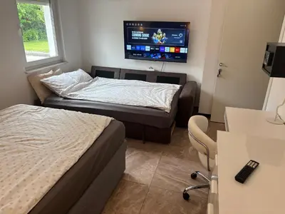 a room with two beds and a tv on the wall at Homestay Free Park&Bikes in Ljubljana