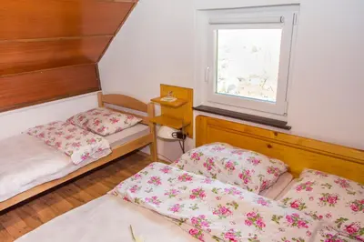 a small room with two beds and a window at Vinska klet Smej in Lendava
