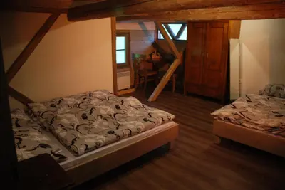 a bedroom with two beds and a stair case at Estate Marjetin dom in Idrija