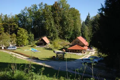 a group of cottages with cars parked in a park at Estate Marjetin dom in Idrija