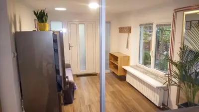 a living room with a refrigerator and a window at Apartma na Ravnicah in Cerkno