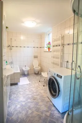 a bathroom with a washer and a washing machine at Apartma na Ravnicah in Cerkno