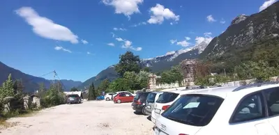 a bunch of cars parked in a parking lot with mountains at Apartma F&M in Bovec