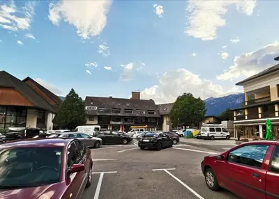 a parking lot with cars parked in front of buildings at Apartma F&M in Bovec