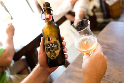 a person holding a bottle and a glass of beer at Domačija Vesel in Trebnje