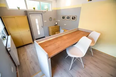 a room with a wooden table and two white chairs at Apartments Stankovo in Krška Vas