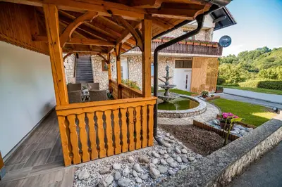 a large wooden deck with a patio and a yard at Apartments Stankovo in Krška Vas