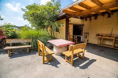 a picnic table and two benches on a patio at Apartment with Sauna pr' Geči in Dobova
