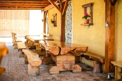 a row of wooden tables and benches in a room at Apartment with Sauna pr' Geči in Dobova
