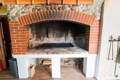 a brick oven with a table in front of it at Apartment with Sauna pr' Geči in Dobova
