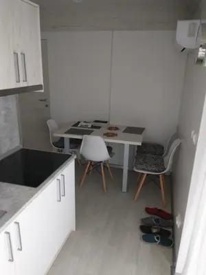 a kitchen with a desk and a table and chairs at Apartments Drevi in Ljubljana